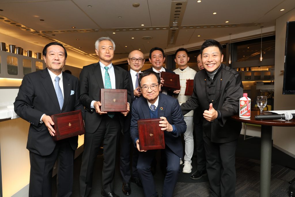 シンポジウムの日本側登壇者に中国ミャオ族の職人手作りのプレゼントを手渡す莫懿鑫資本集団会長、張晓北京玄鸟錾文化发展有限公司会長